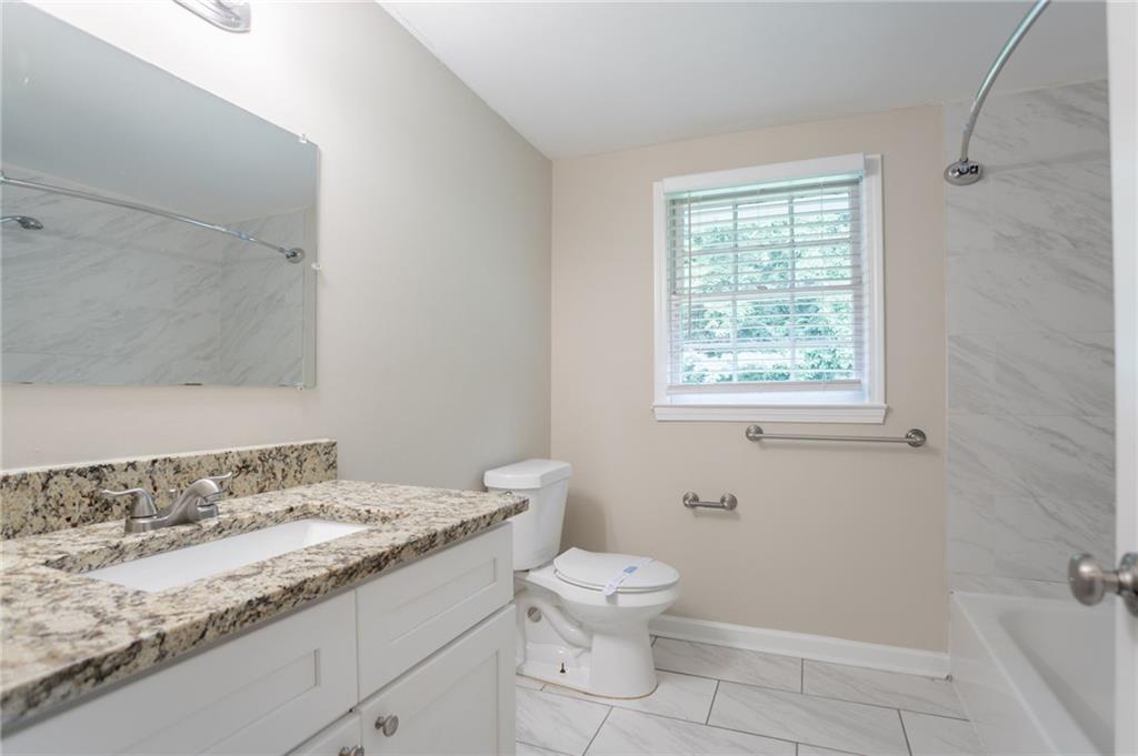 542 Hasty Drive Lithia Springs, GA 30122 - Photo 23 of 44 a bathroom with a granite countertop sink a toilet and shower