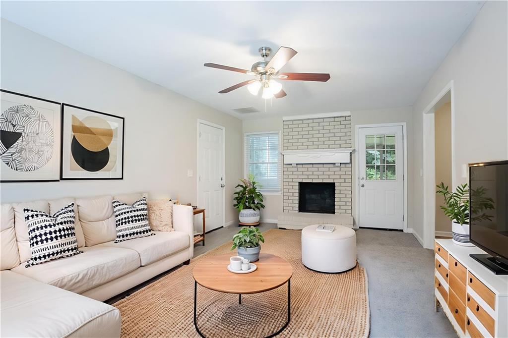 542 Hasty Drive Lithia Springs, GA 30122 - Photo 4 of 44 a living room with furniture a fireplace and a flat screen tv