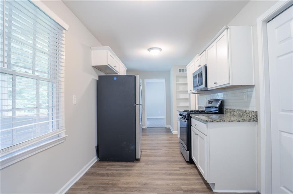 542 Hasty Drive Lithia Springs, GA 30122 - Photo 7 of 44 a kitchen with granite countertop a refrigerator and a stove