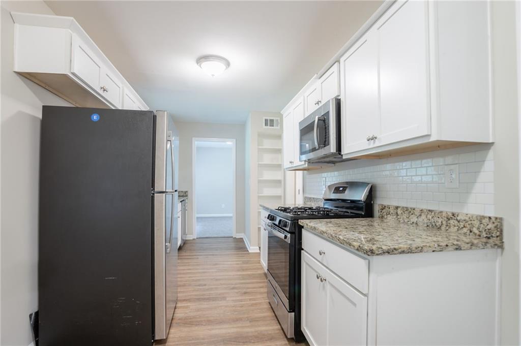 542 Hasty Drive Lithia Springs, GA 30122 - Photo 10 of 44 a kitchen with stainless steel appliances granite countertop a refrigerator and a stove top oven