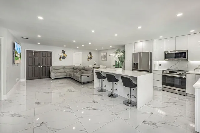 a kitchen with stainless steel appliances kitchen island granite countertop a sink and cabinets