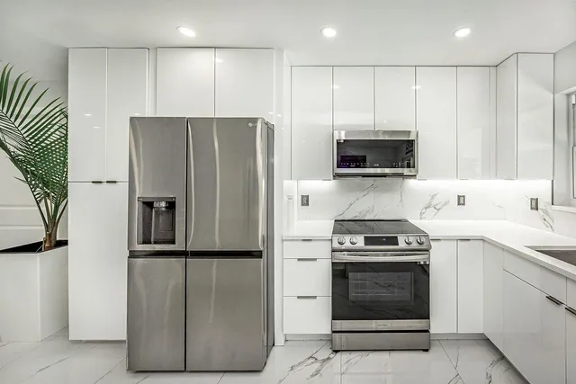 a kitchen with stainless steel appliances granite countertop a refrigerator stove and sink