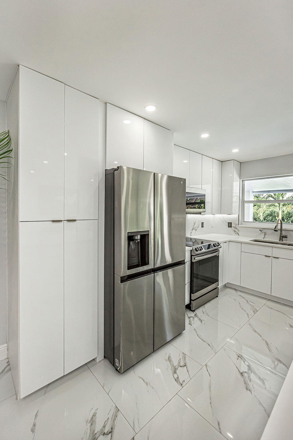 1881 Caribbean Road West Lake Clarke Shores, FL 33406 - Photo 17 of 40 a kitchen with granite countertop a refrigerator and a sink