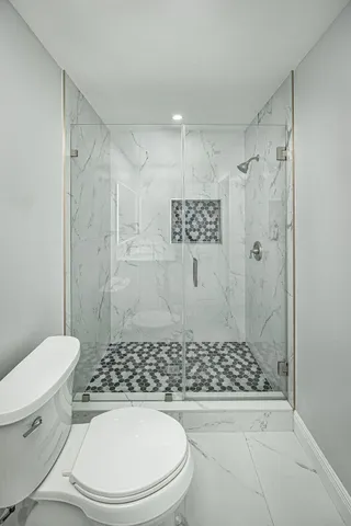a bathroom with a toilet and a shower