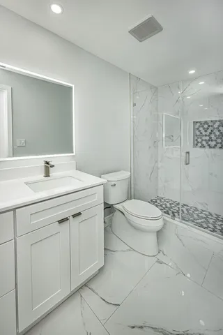 a bathroom with a sink a toilet and shower