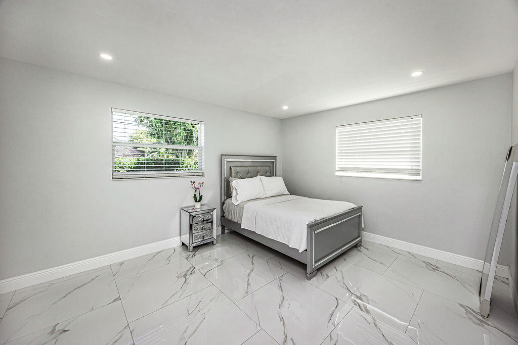 1881 Caribbean Road West Lake Clarke Shores, FL 33406 - Photo 27 of 40 a bedroom with a bed and window