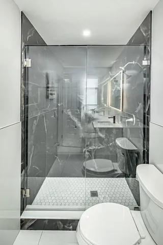 a bathroom with a double vanity sink toilet and shower
