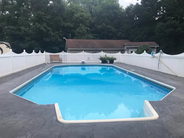 a view of a small house with wooden fence