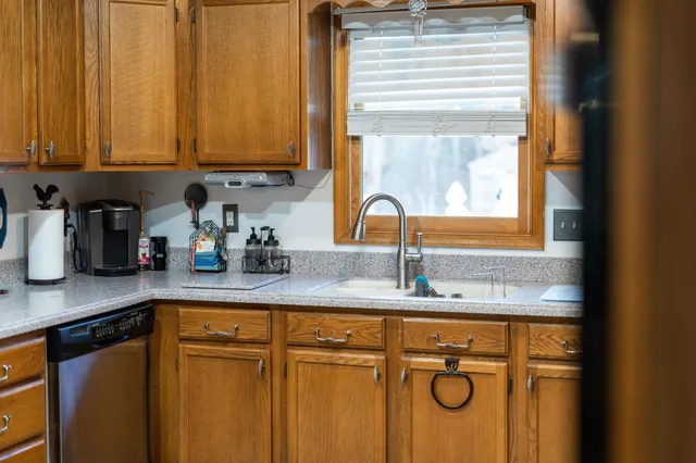 a bed sitting in a bedroom next to a window with pc on the table