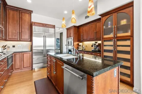 a kitchen with stainless steel appliances granite countertop a sink a stove and a refrigerator