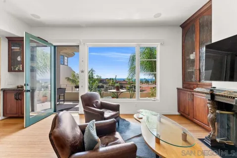 a living room with furniture a large window and a wooden floor