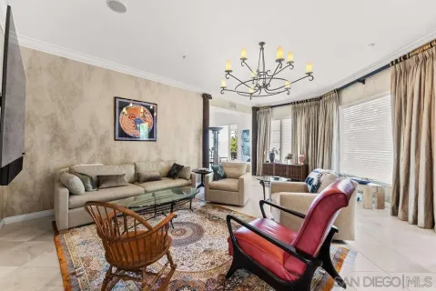 a living room with furniture a large window and a chandelier