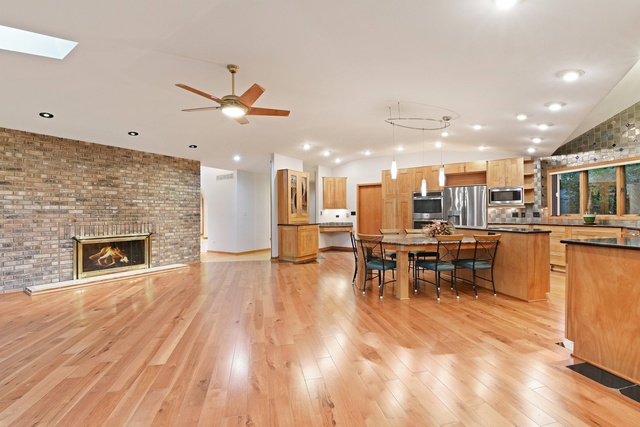 18N313 Sawyer Road Dundee, IL 60102 - Photo 8 of 24 a open kitchen with stainless steel appliances kitchen island a stove a refrigerator a fireplace with a dining table and chairs with wooden floor