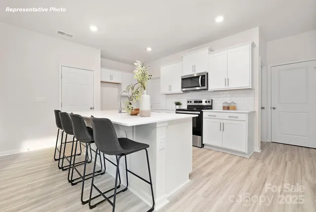 a kitchen with a sink cabinets and wooden floor