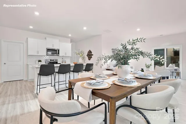a dining room with furniture a chandelier and kitchen view