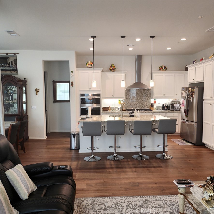11882 Wandering Way Corona, CA 92883 - Photo 5 of 38 a kitchen with stainless steel appliances kitchen island granite countertop a stove a sink a refrigerator and a refrigerator