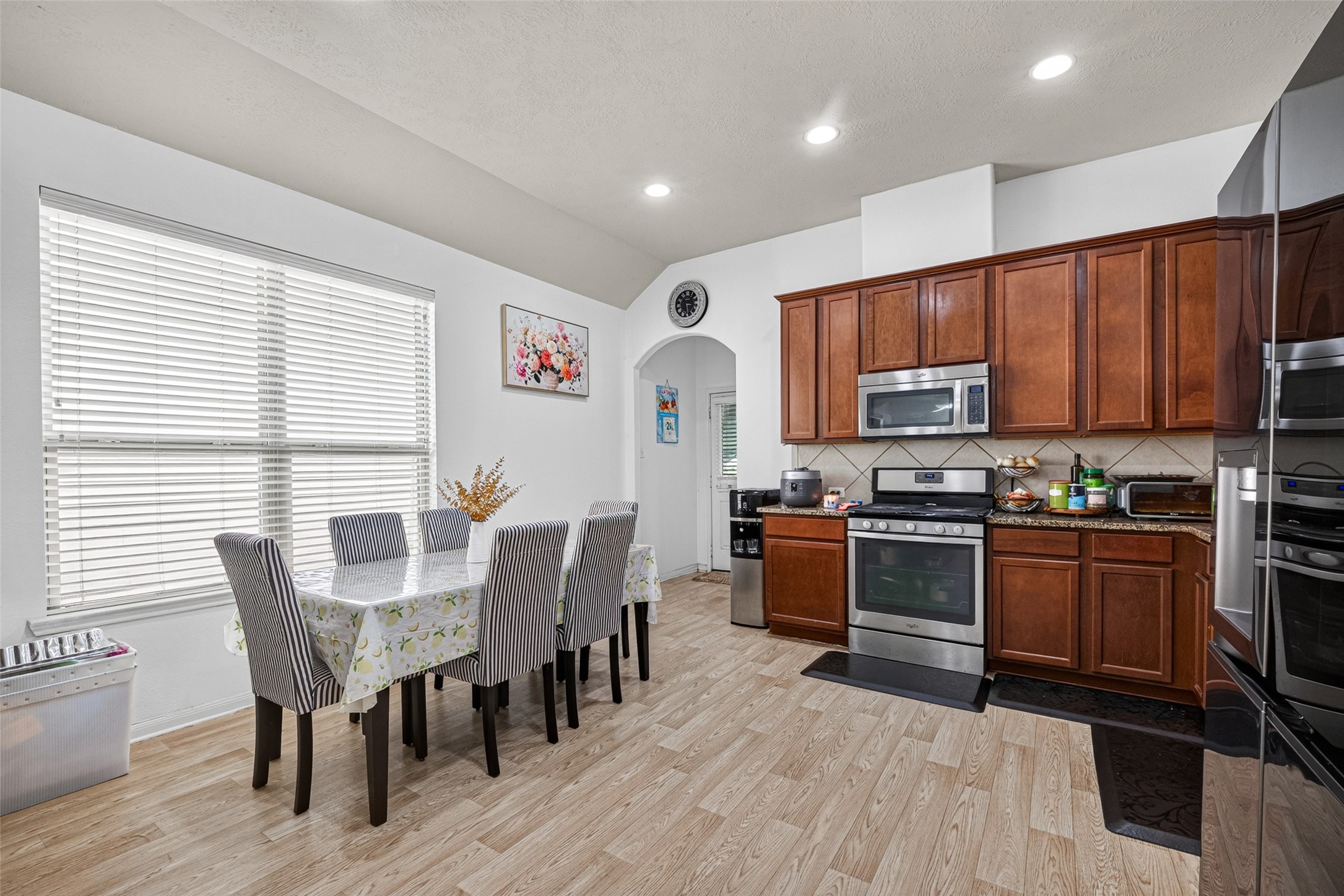 9314 Fuqua Ridge Lane Houston, TX 77075 - Photo 9 of 24 a kitchen with stainless steel appliances granite countertop a stove top oven a sink dishwasher a dining table and chairs with wooden floor