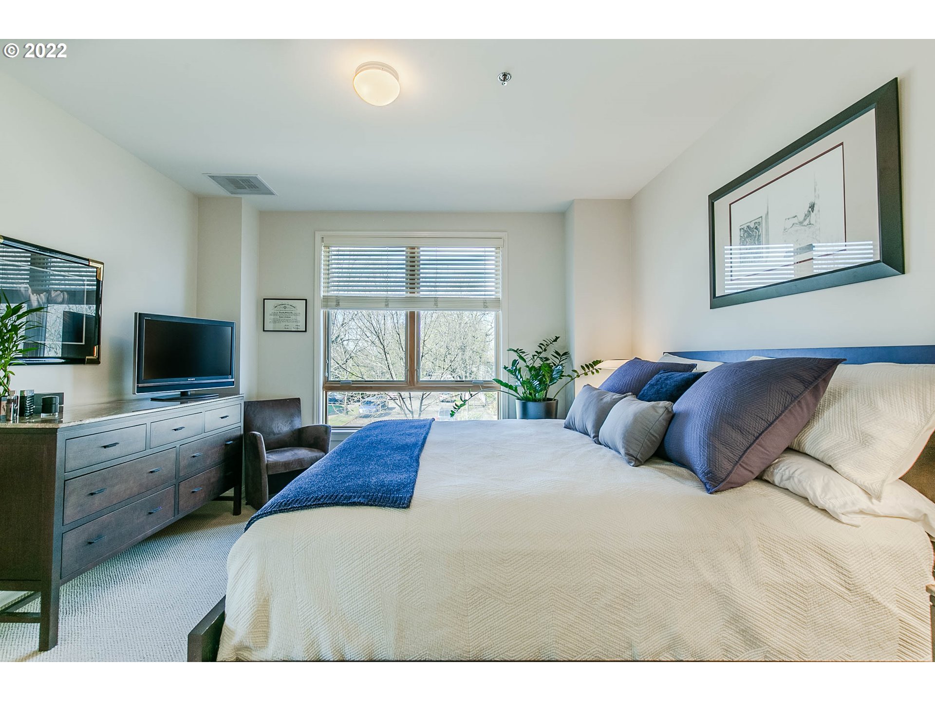 1375 Olive Street, Unit 201 Eugene, OR 97401 - Photo 23 of 32 a bedroom with a large bed and a flat screen tv
