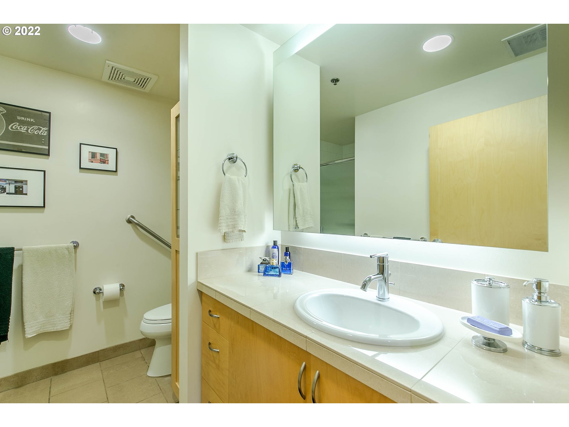 1375 Olive Street, Unit 201 Eugene, OR 97401 - Photo 27 of 32 a bathroom with a granite countertop sink a toilet a mirror and shower