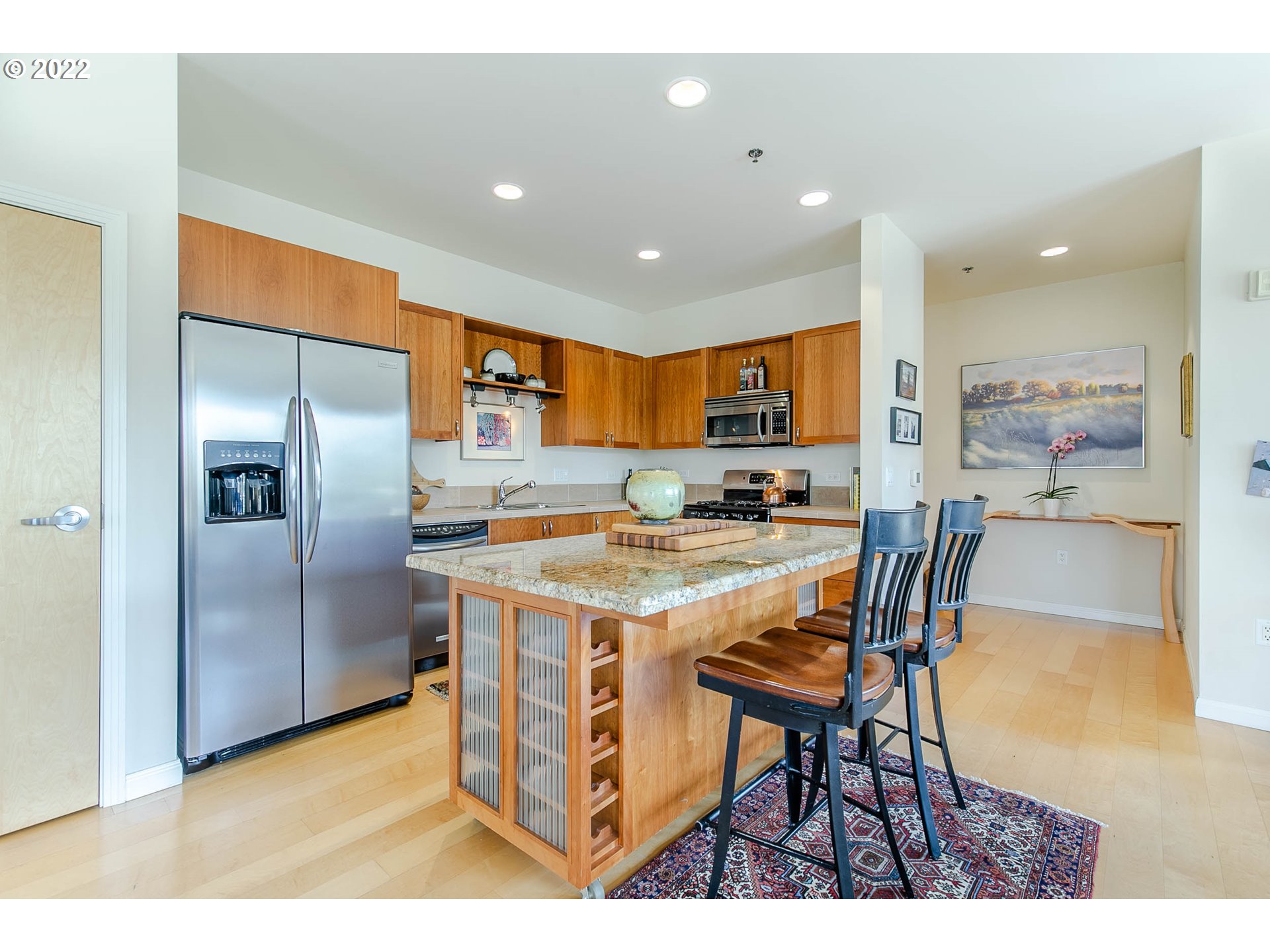 1375 Olive Street, Unit 201 Eugene, OR 97401 - Photo 8 of 32 a kitchen with stainless steel appliances granite countertop a table chairs and a refrigerator
