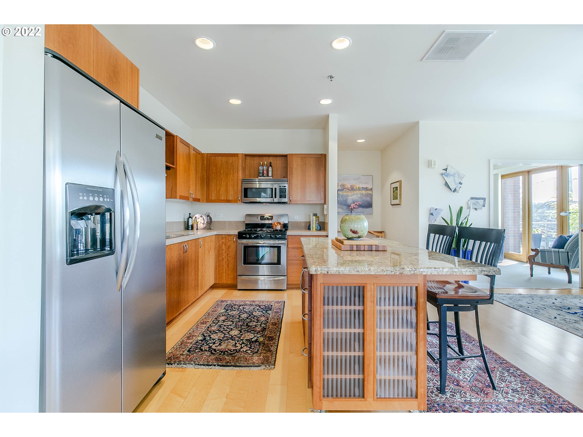 1375 Olive Street, Unit 201 Eugene, OR 97401 - Photo 9 of 32 a kitchen with stainless steel appliances kitchen island granite countertop a refrigerator a stove top oven and a sink