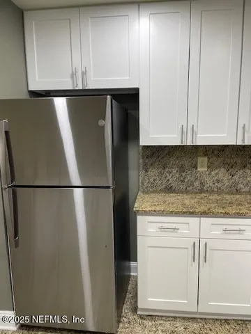 a kitchen with granite countertop a sink a stove and cabinets