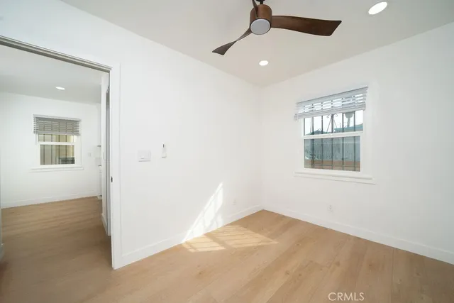an empty room with a window and ceiling fan