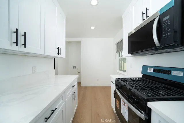 a kitchen with stainless steel appliances a stove microwave and sink