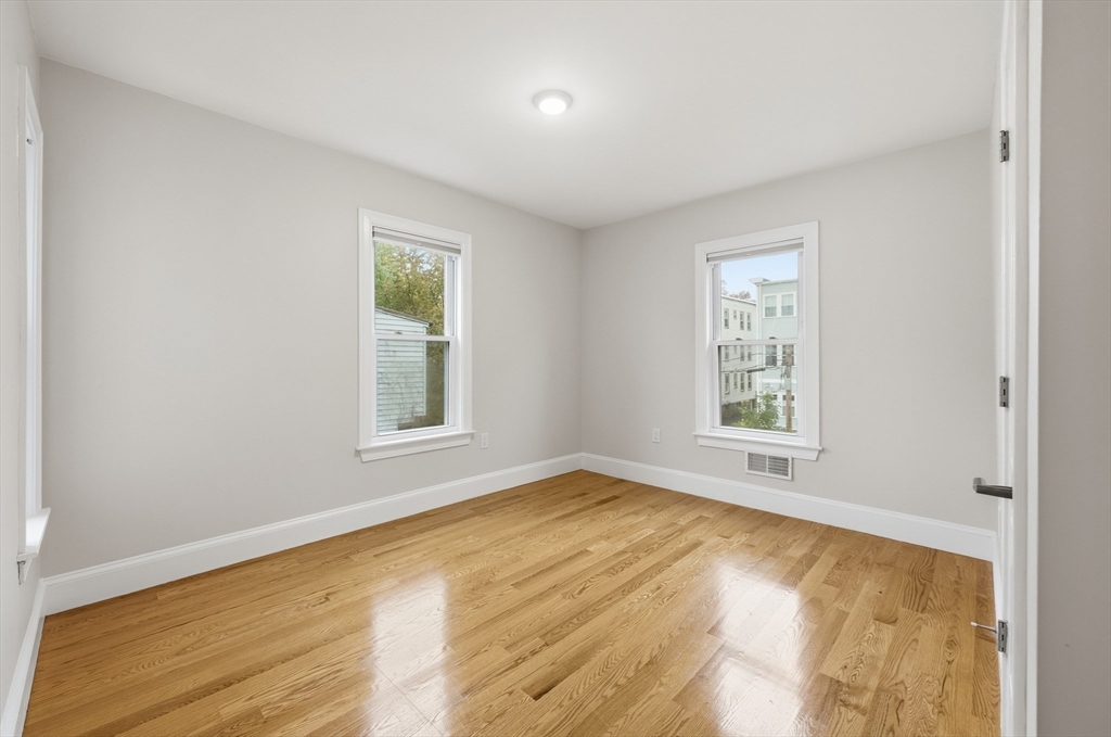 31 Chipman Street Boston, MA 02124 - Photo 23 of 37 a view of an empty room with wooden floor and a window