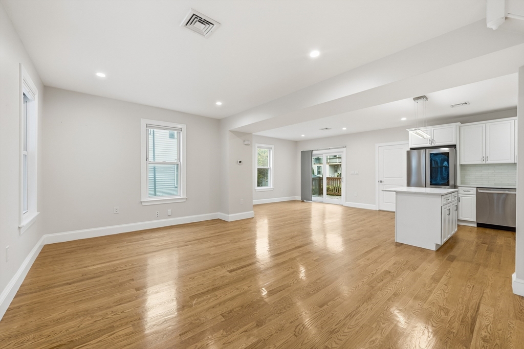 31 Chipman Street Boston, MA 02124 - Photo 3 of 37 a view of empty room with wooden floor and kitchen view