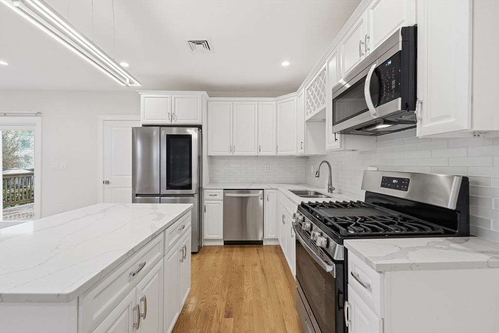 31 Chipman Street Boston, MA 02124 - Photo 7 of 37 a kitchen with stainless steel appliances granite countertop a stove a sink and a microwave