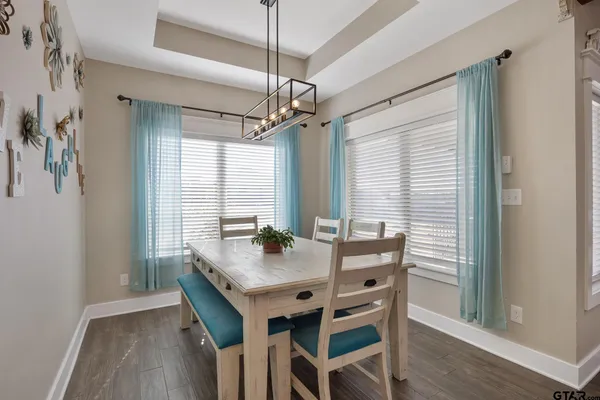 a kitchen with stainless steel appliances granite countertop a sink dishwasher a refrigerator and a stove with wooden floor