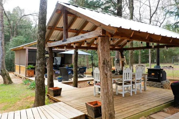 a view of a patio with table and chairs potted plants with wooden floor and fence