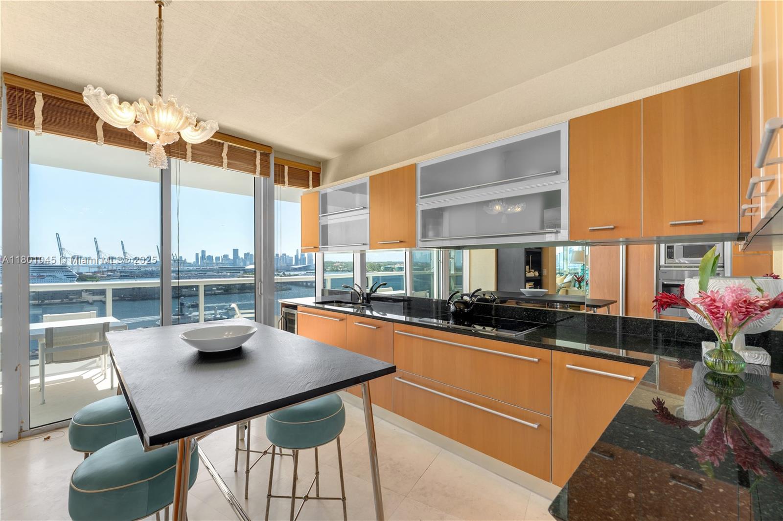 400 Alton Road, Unit 1101 Miami Beach, FL 33139 - Photo 17 of 31 a kitchen with stainless steel appliances kitchen island granite countertop a table chairs in it and wooden floor