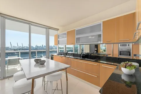 a kitchen with a table chairs stove and granite counter top
