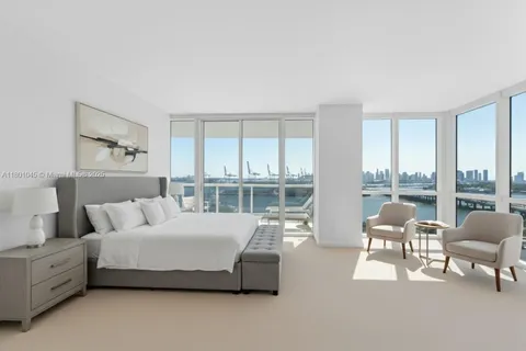 a spacious bedroom with a bed and large windows