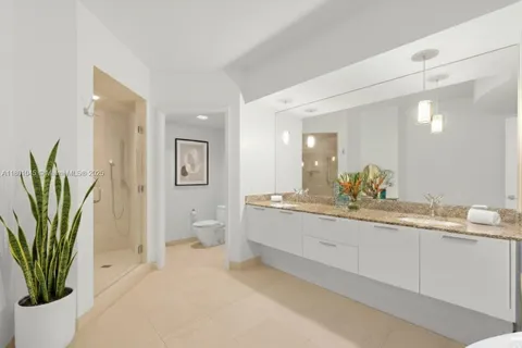 a spacious bathroom with a granite countertop sink a toilet and a large mirror