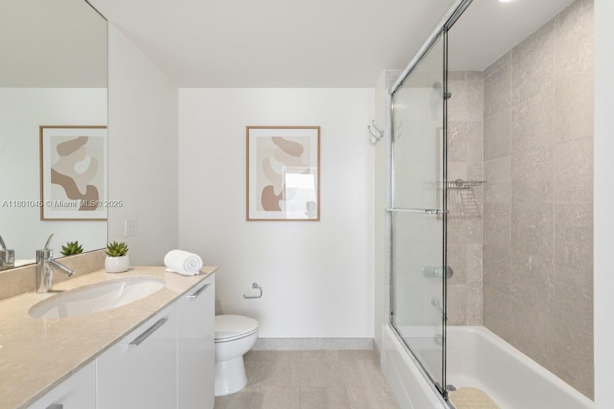 400 Alton Road, Unit 1101 Miami Beach, FL 33139 - Photo 7 of 31 a bathroom with a granite countertop sink toilet and shower