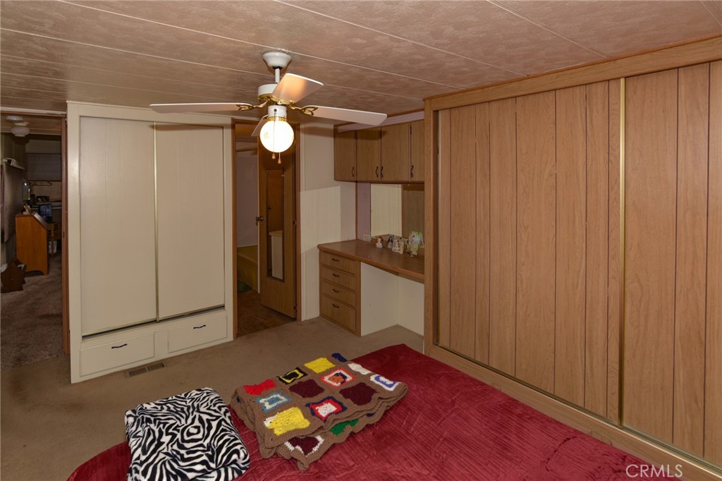 23456 Ottawa Road, Unit 4 Apple Valley, CA 92308 - Photo 11 of 17 a bedroom with a bed and a chandelier