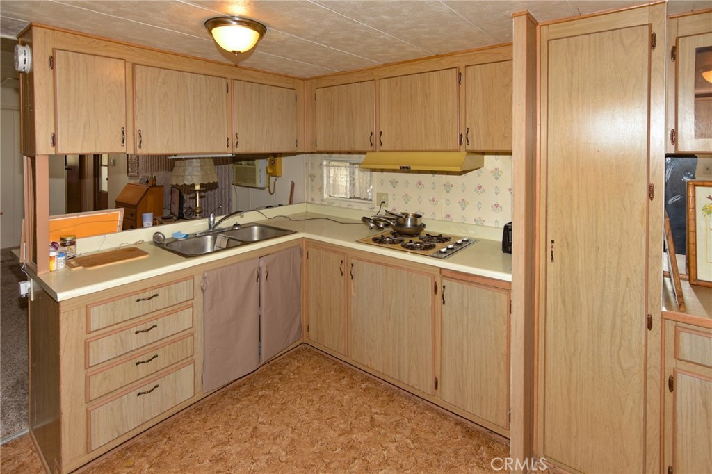 23456 Ottawa Road, Unit 4 Apple Valley, CA 92308 - Photo 4 of 17 a kitchen with white cabinets and appliances