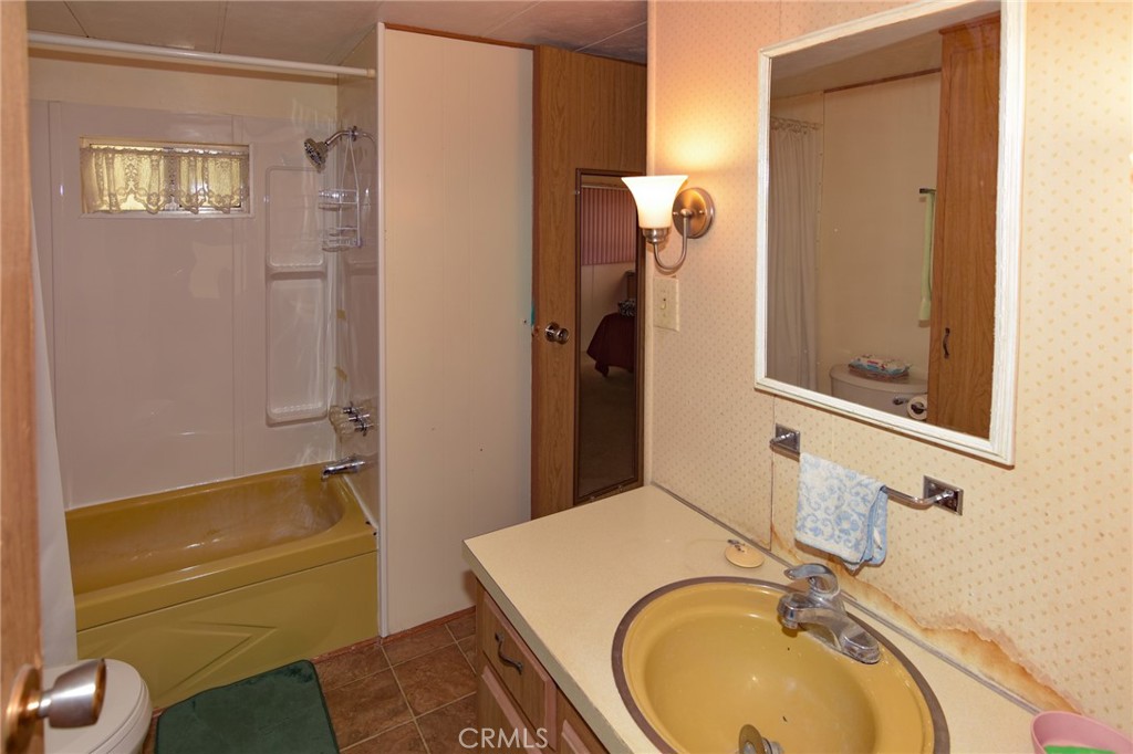 23456 Ottawa Road, Unit 4 Apple Valley, CA 92308 - Photo 9 of 17 a bathroom with a sink a toilet and a mirror