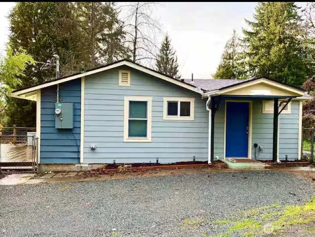 a view of a house with a yard and large tree