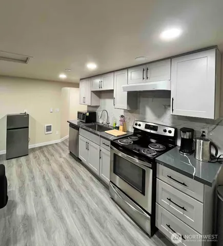 a kitchen with granite countertop a stove sink and cabinets