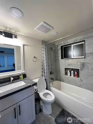 a bathroom with a toilet a sink a mirror and bathtub