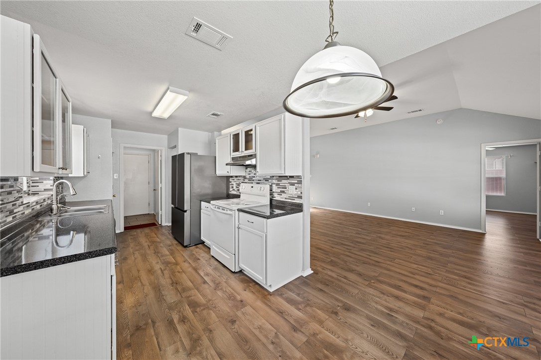 305 James Loop Killeen, TX 76542 - Photo 10 of 32 a large white kitchen with a large window a oven a sink and white cabinets