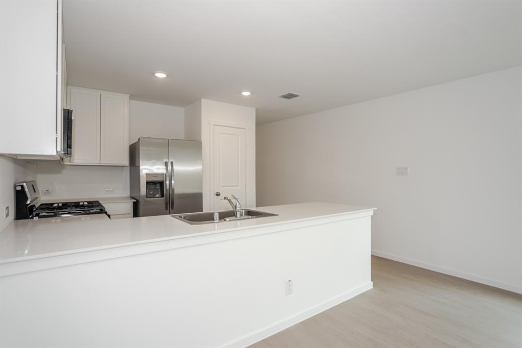 1419 Merlin Blf Street Forney, TX 75126 - Photo 10 of 24 Spacious room featuring light wood-finish flooring, white walls, and recessed lighting