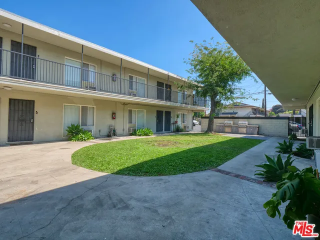 a view of a big building with a big yard and large trees