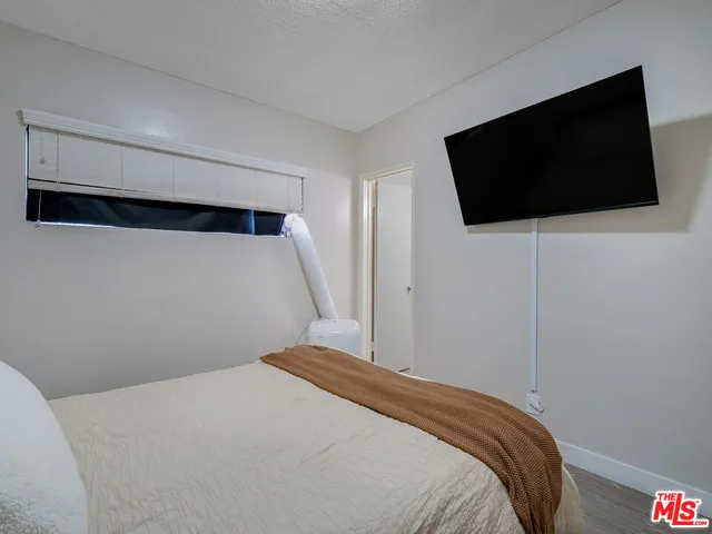 a bedroom with a bed and a flat screen tv