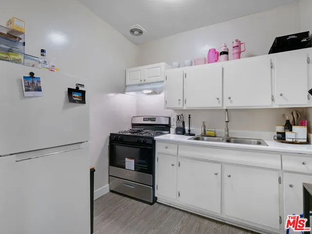 a kitchen with granite countertop white cabinets and white appliances