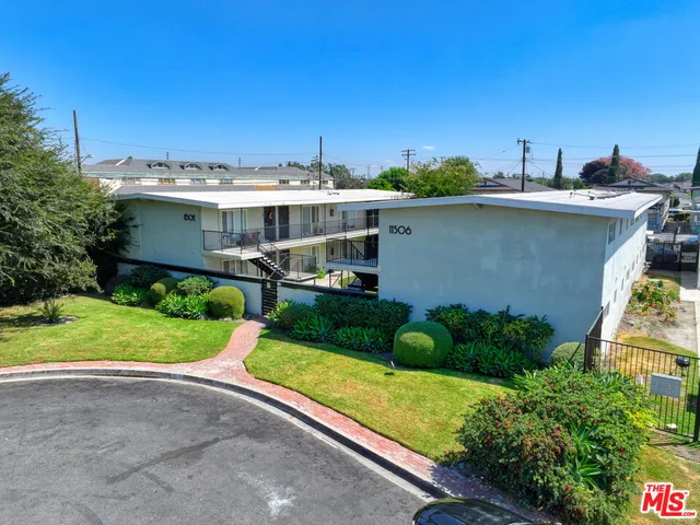 a view of a house with a yard and potted plants